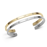 Daniel Wellington Classic Lumine Braceletのシルバーとゴールド2本セットです。細身のカフデザインにクリスタルとロゴが等間隔に配され、ポリッシュ仕上げの異なるメタルトーンが上品なコントラストを演出しています。