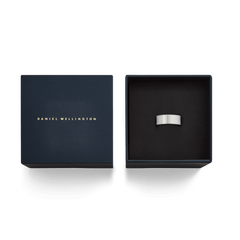 ネイビーのDaniel Wellingtonギフトボックスに収められたLine Ring Brushed Silver 8mmです。箱の蓋にはゴールドのブランドロゴが箔押しされ、黒いクッションカバーの上にブラッシュドシルバーのリングが置かれています。