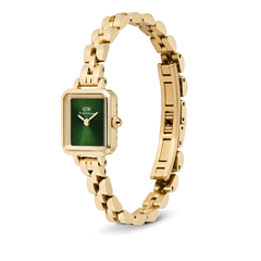 Quadro Mini Arch Emerald Sunray Goldを斜めから捉えた画像です。アーチ型の3リンクブレスレットが持つ丸みのある連なりや、バタフライバックルの細部、そしてエメラルドグリーンのサンレイダイヤルに宿る深い輝きがご覧いただけます。
