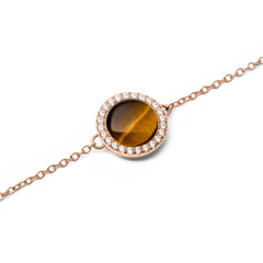 Audrey Bracelet Tiger Eye Rose Goldのチャーム部分をクローズアップした画像です。ドーム型のタイガーアイには、蜂蜜色からダークブラウンへと移り変わる絹糸のような光沢が美しく映え、周囲を彩るホワイトキュービックジルコニアとローズゴールドのチェーンが繊細に調和しています。