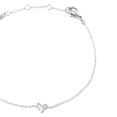 おひつじ座をモチーフにしたCrystal Zodiac Chain Bracelet Silverのクローズアップ画像です。キュービックジルコニアがあしらわれた牡羊座のチャームと、なめらかなシルバーチェーンのつながりがご覧いただけます。ロブスタークラスプやブランドプレートも確認できます。