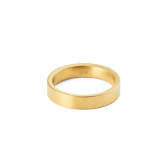 ダニエルウェリントン Line Ring Brushed Goldをやや低めのアングルから撮影した画像です。内側にはDaniel Wellingtonの刻印が施されており、ブラッシュド仕上げの落ち着いたゴールドカラーと、シンプルなフラットバンドのデザインが白い背景に映えています。