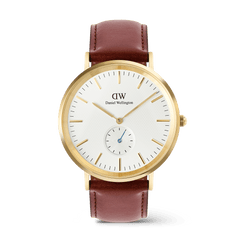 Daniel Wellington Classic Multi-Eye St Mawesの正面からのプロダクトショットです。ゴールドケースにオフホワイトのサンレイ文字盤、6時位置にブルーの秒針が映えるサブセコンドダイヤル、そしてブラウンのレザーストラップを組み合わせたメンズ腕時計です。
