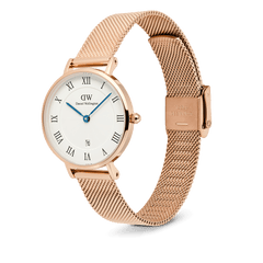 ローズゴールドのプレスメッシュストラップが映えるPetite Roman Numerals Date Rose Gold。斜めからのアングルで、ギョーシェ模様のホワイトダイヤルとブルーの針の美しいコントラストや、ストラップの編み目と折り返し式クラスプのディテールが際立ちます。