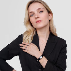 ブラックのジャケットを合わせた女性が、シルバーのレクタンギュラー型腕時計とブラックレザーストラップ、パールのスタッドピアス、パールネックレス、シルバーリングをコーディネートした着用イメージです。