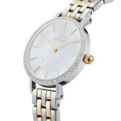 Petite Lumine Bezel 5-Link Two-Tone MOPを斜めからとらえたクローズアップ画像です。マザーオブパールの文字盤が放つ柔らかな光沢、クリスタルベゼルの繊細な輝き、そしてシルバーとゴールドが交互に連なる5リンクブレスレットのポリッシュ仕上げが美しく映えています。
