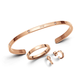 Daniel WellingtonのLumine Jewelry Setを白背景に並べた商品写真。カフブレスレット、リング、フープピアスは、ポリッシュ仕上げのローズゴールドに小粒のクリスタルが等間隔にあしらわれ、統一感のある上品なデザインが際立ちます。