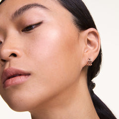 ダニエルウェリントンの5-Link Earrings ローズゴールドを着用したモデルのクローズアップです。コンパクトな5連リンクのフープピアスが耳元で上品に輝き、ナチュラルメイクとの相性も抜群です。