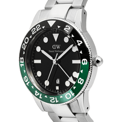 Iconic GMT Link Black Green Ceramic Bezelを斜めから捉えたクローズアップ画像です。ブラックからグリーンへと変化するセラミックベゼルの24時間表示や、ブラック文字盤上のルミノバインデックス、GMT針の細部まで確認できます。ローレット加工のリューズやシルバーのリンクブレスレットの質感も際立っています。