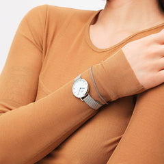 シルバーのDaniel WellingtonとTide Mesh Bracelet Sterling 1.8を重ね付けした着用イメージです。キャメルカラーのトップスに合わせ、手元にさりげない統一感を添えています。