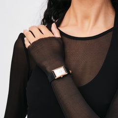 ブラックのトップスを着た女性が、Daniel WellingtonのBound Black Crocodile Rose Goldを手首に着用している様子です。長方形のローズゴールドケースとブラックレザーストラップが、シックな装いに自然になじんでいます。