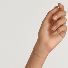 Daniel Wellington Twisted Chain Braceletのローズゴールドモデルを手首に着けた様子です。細身のツイストチェーンが肌になじみ、控えめながらも上品な輝きを放ちます。