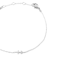 いて座をモチーフにしたCrystal Zodiac Chain Bracelet Silverを斜め上から撮影した接写画像です。キュービックジルコニアでデザインされた矢のチャームが、繊細なシルバーチェーンの中央にあしらわれています。ロブスタークラスプやブランドプレートの一部も確認できます。