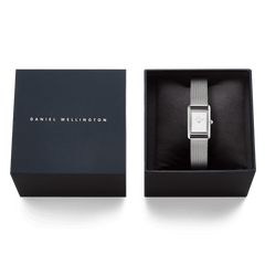 ダークネイビーのブランドギフトボックスに収められたBound Mini Sterlingの画像です。クッションの上にシルバーメッシュベルトのレクタンギュラータイプの腕時計が丁寧にセットされており、贈り物にぴったりの上品なパッケージングが印象的です。