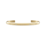 Daniel Wellington Classic Lumine Braceletのゴールドオープンカフ。ポリッシュ仕上げの表面にはクリスタルとブランドロゴが交互に配置され、内側はサテン仕上げとなっています。