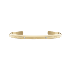 Daniel Wellington Classic Lumine Braceletのゴールドオープンカフ。ポリッシュ仕上げの表面にはクリスタルとブランドロゴが交互に配置され、内側はサテン仕上げとなっています。