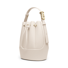 Lewis Bag Crèmeを斜め前方から撮影した画像です。ドローストリングを閉じた状態で、クリーム色のエコレザーが描く丸みのあるバケツ型シルエットと、ハンドル右側に配されたウェーブ型のゴールドバックルが確認できます。
