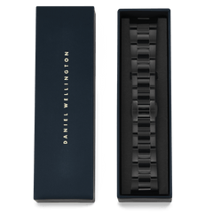 Daniel Wellingtonのギフトボックスに収められたSmartwatch Iconic Link Onyxの画像です。ブラックPVDコーティングの3連リンクブレスレットがボックス内のクッションに丁寧にセットされ、ゴールドのブランドロゴがあしらわれた蓋が横に添えられています。