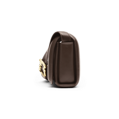 ダニエルウェリントン Sadie Bag Brownを横から撮影した画像です。コンパクトな厚みと、フラップの丸みを帯びたシルエットが特徴で、サイドにはゴールドのウェーブバックルが映えています。