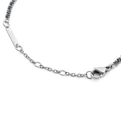 Classic Tennis Bracelet Nightfall Silverの留め具部分のディテール画像です。ロブスタークラスプとサイズ調節用のチェーン、Daniel Wellingtonの刻印が入ったブランドプレートが確認できます。また、両端にはダークトーンのクリスタルが連なっています。