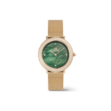 白背景で斜め上から撮影したCrystalline Bezel Evergold Greenの商品画像です。グリーンマザーオブパールの深みのある色合いと、ベゼルを二重に彩るクリスタルの輝き、ゴールドメッシュストラップの質感が立体的に表現されています。