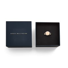 ネイビーカラーのブランドギフトボックスに収められたClassic Signet Ring Rose Goldの俯瞰画像です。ゴールドのロゴがあしらわれた蓋と、黒いクッショントレーに置かれたローズゴールドのリングが、贈り物にぴったりの上品なパッケージを演出しています。