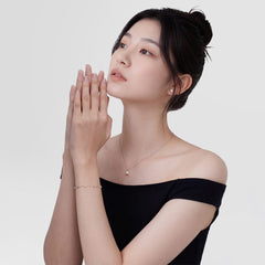 ダニエルウェリントンのPearl Bracelet Silverを着用した女性モデル。黒のオフショルダートップに合わせ、細身のシルバーチェーンにパールとクリスタルが繊細に輝くブレスレットが手首を上品に彩ります。同シリーズのパールネックレスと合わせることで、統一感のあるコーディネートが楽しめます。