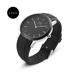 Iconic Motion Silver 44mmモデルを斜め上から捉えた画像です。ブラックベゼルとシルバーケースのサイド部分による二層構造が立体感を演出し、ブラック文字盤に配されたシルバーバーインデックスが光を反射して浮かび上がります。マットブラックのFKMラバーストラップには、ブランド名がエンボス加工で施されています。