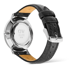 Classic Roman Numerals Date Black Croc Belly Silverの裏蓋側を撮影した製品写真です。ポリッシュ仕上げのステンレススチール製ケースバックには、ブランドロゴやシリアルナンバーが刻印されています。ブラッククロコベリーレザーストラップの内側には、キャメルカラーのライニングが施されており、シルバーのピンバックルにはブランドイニシャルが刻まれています。