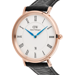 ローズゴールドケースの「Classic Roman Numerals Date Black Croc Belly Rose Gold」を斜めアングルからクローズアップ。ホワイト文字盤に配されたローマ数字とブルースチールの針が鮮やかなコントラストを描き、ケースのポリッシュ仕上げやリューズのディテール、ブラッククロコベリーレザーの型押し模様が際立ちます。
