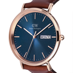 Classic Day Display St Mawes Rose Gold Arcticの文字盤をクローズアップした画像です。ブルーの文字盤全体に広がるトライアングルテクスチャーの繊細な模様や、ローズゴールドのバーインデックス、3時位置に配された曜日・日付表示窓が鮮明に捉えられています。リューズのローレット加工やケースのブラッシュ仕上げによる質感も際立つアングルです。