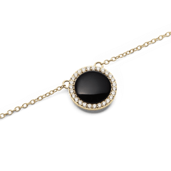 Audrey Necklace Black Agathe Goldのペンダント部分をクローズアップした画像です。ドーム型の黒メノウが光を受けて艶やかに輝き、周囲を彩るホワイトキュービックジルコニアとゴールドフレームの細やかなディテールが際立ちます。