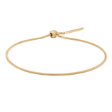 Daniel Wellington Charms Snake Bracelet Gのゴールドスネークチェーン全体をご覧いただけます。スライド式の丸型留め具とバーエンドが特徴で、細やかな鱗状の表面が光を受けて上品に輝きます。