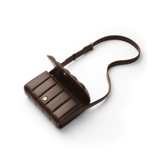 ダニエルウェリントンのSadie Bag Brownを斜め上から撮影した全体像です。フラップを半開きにした状態で、マグネット留め具と縦パフキルティングの立体的なラインが際立っています。長さ調節可能なブラウンレザーのストラップは、自然なカーブを描いています。