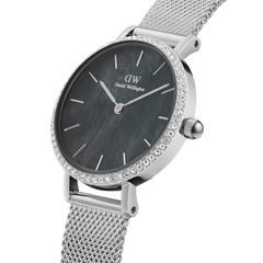 Petite Lumine Bezel Sterling Black MOPの文字盤とクリスタルベゼルを斜めから捉えたクローズアップ画像です。ブラックマザーオブパールの深みのあるグレーの色合い、シルバーのインデックス、そしてメッシュストラップの細やかな編み目が際立ちます。