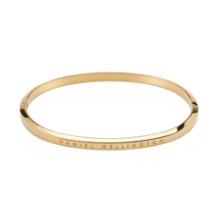 ダニエルウェリントン Classic Bangle Goldを上から撮影した製品画像です。ポリッシュ加工のゴールドカラーが上品な光沢を放ち、表面にはダニエルウェリントンのロゴが刻印された細身のバングルです。