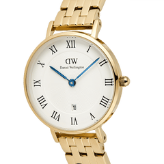 Petite Roman Numerals Date 5-link Goldのダイヤルを正面からクローズアップした画像です。ホワイトダイヤル中央に広がるギョーシェ模様の繊細な質感や、ブルーの時分針、ゴールドケースのポリッシュ仕上げ、リューズの細部まで確認できます。