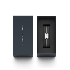 Quadro Mini Lumine Bezelのギフトボックス入り画像です。ネイビーのブランドボックスに、クリスタルベゼルが輝くシルバーメッシュストラップの腕時計が丁寧に収められています。贈り物にぴったりの上品なパッケージです。