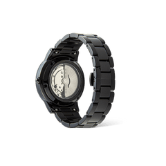 Iconic Link Automatic Blackの裏面を捉えた画像です。サファイアガラスのエキシビションケースバック越しに、自動巻きムーブメントのローターや歯車が見え、ブラック仕上げのリンクブレスレットのヘアラインとポリッシュの質感が際立っています。