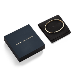 ダニエルウェリントン Classic Bangle Goldとネイビーカラーのギフトボックス、ブラックのスエード調ポーチをセットにしたパッケージ画像です。贈り物としてもそのままお渡しいただける、上品な仕様となっています。