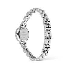 Petite Mini Arch 3-link White Silverの裏蓋側から撮影した画像です。Daniel Wellingtonのロゴが刻印されたケースバックと、バタフライ式の留め具の構造が確認できます。シルバーのアーチ型3リンクブレスレットは円を描くように配され、各リンクの立体感と上質な研磨仕上げが際立っています。