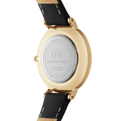 Petite Roman Numerals Sheffield Goldの裏蓋をご紹介します。Daniel Wellingtonのロゴとシリアルナンバーが刻印されたステンレススチール製の裏蓋、ゴールドケースの滑らかな側面、そしてブラックレザーストラップのホワイトステッチが確認できます。