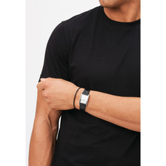 ブラックのTシャツにBound Black Crocodile Silverを合わせ、ブラックレザーブレスレットと重ね付けした男性のコーディネートです。長方形のケースとクロコダイル型押しのストラップが手首にすっきりとフィットし、モノトーンのスタイリングに自然になじんでいます。