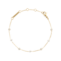 ダニエルウェリントンのPearl Bracelet Goldです。細やかなゴールドチェーンにホワイトパールとクリアストーンが交互にあしらわれ、ロブスタークラスプとブランドロゴの刻印プレートが付いています。