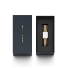 ダニエルウェリントンのギフトボックスに収められたQuadro Lumine Bezel Evergold MOPの俯瞰画像です。箔押しのブランドロゴがあしらわれた蓋と、黒いクッションカバーの上にゴールドメッシュストラップのスクエアウォッチが丁寧にセットされています。