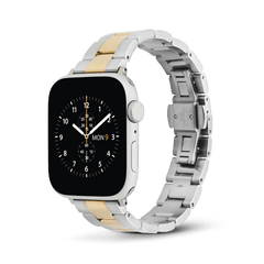 Daniel Wellington Smartwatch Iconic Linkのツートンブレスレットを装着したApple Watchを、正面やや斜めから撮影した製品写真です。シルバーのヘアライン仕上げとゴールドのポリッシュ仕上げのコントラストが美しく際立ち、裏側にはステンレススチール製のバタフライバックルが確認できます。
