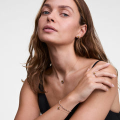 Daniel Wellington Audrey タイガーアイコレクションを身に着けたスタイリング例。ブレスレット、ネックレス、リング、ピアスを合わせ、琥珀色のタイガーアイとシルバーチェーンが黒のトップスに映えるコーディネートです。