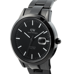 Iconic Link Automatic Blackを斜めからとらえたクローズアップ画像です。ヘアラインとポリッシュの組み合わせによるブラックケースの質感、夜光インデックスのコントラスト、3時位置の日付拡大窓、そしてブラックのリューズが確認できます。