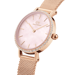 Petite Lumine Bezel Melrose Pink MOPを斜めから捉えたクローズアップ写真です。ピンクマザーオブパールの文字盤が放つ柔らかな輝きや、ベゼルにあしらわれたクリスタルの煌めき、ローズゴールドのメッシュストラップの細やかな編み目が際立ちます。
