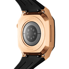 Daniel Wellington Switch Rose Goldの裏面画像です。ステンレススチール製ケースの背面にはブランド名やシリアルナンバーの刻印が施され、Apple Watchのセンサー部分が中央に収まる構造が確認できます。ブラックのFKMラバーストラップとの接続部分も見え、頑丈な作りが伝わります。